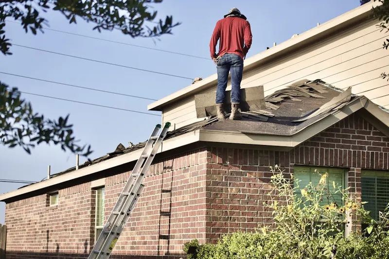 Professional roofer working on a residential roof in Pennypacker Park